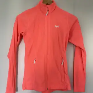 Fleece jacka i neon orange färg med fragkedje fickor