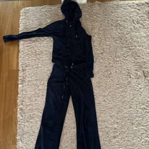 Ginatricot velour set - Säljer ett jättefint cecilia velour set i mörkblå. Koftan är i storlek XS och byxorna XXS. Sparsamt använda, dock har öglan på dragkedjan på koftan gått sönder, men det stör inte något enligt mig. Settet för 200 (köpt för 600), och 100kr/st.💕