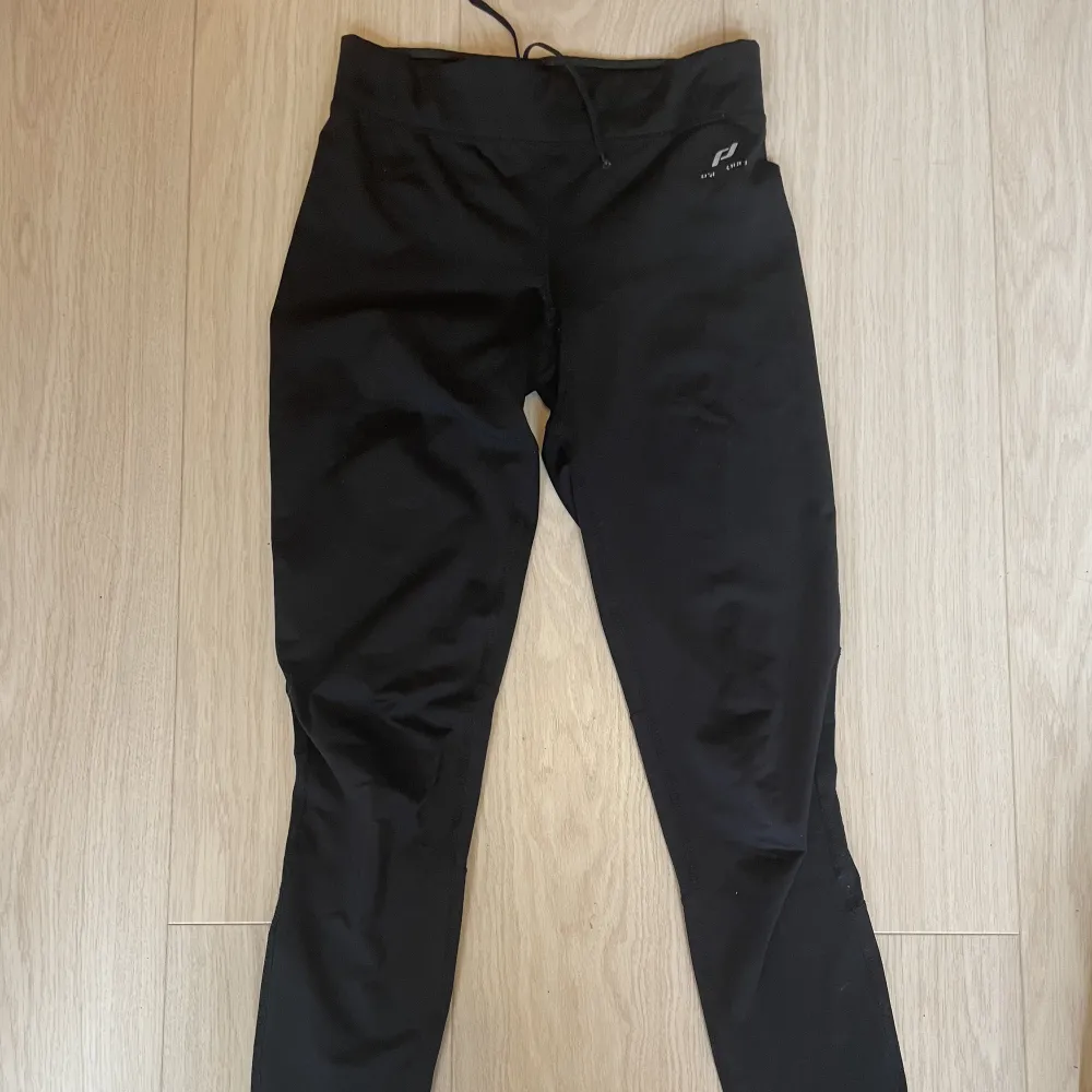 Svarta stretch träningsbyxor med ficka som har dragkedja bak. Jeans & Byxor.