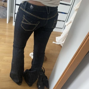 Lågmidjade jeans - Supersnygga jeans i mörkmörkblå/svart med jättefina guldiga detaljer. Lite för små för mig. Strl S. Jag är 161 men de passar längdmässjgt typ lite långa. Midja 34,5 cm, innerben 78 cm. 400kr o köp GÄRNA via köp nu!