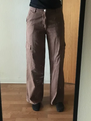 Cargobyxor - Ett par bruna cargobyxor. Använda 1 gång. Kommer inte till användning. Är 174