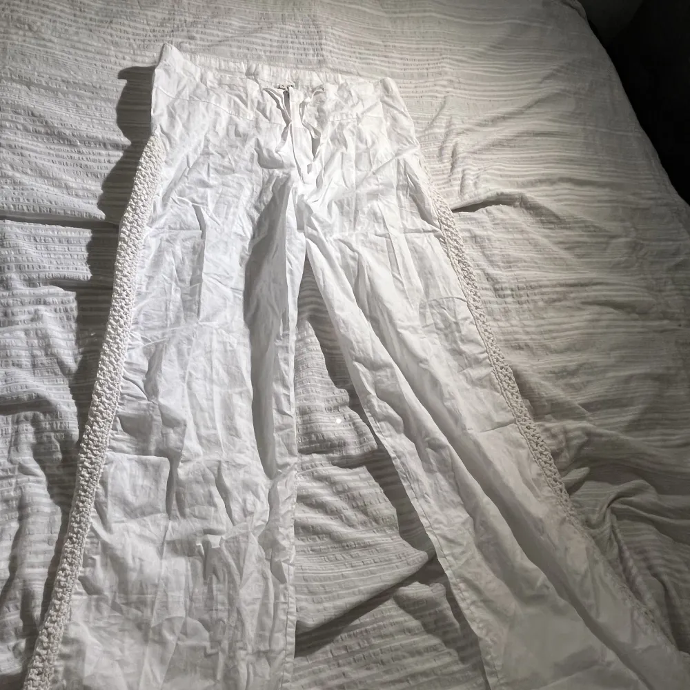 Lågmidjade Vita linne byxor från Spanien, har virkade detaljer vid sömmarna på ytterkanten vid benen, storlek S super snygga med fickor därbak men de passar inte mig i midjan tyvärr!!!. Jeans & Byxor.