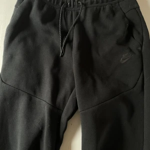Nike tech byxor (svart) - Säljer mina svarta nike tech byxor då jag inte använder dom. Kan gå ner till 300 vid snabb affär. Sorry för dåliga bilder men det är fan skit svårt att få bra bilder på byxorna vet inte varför