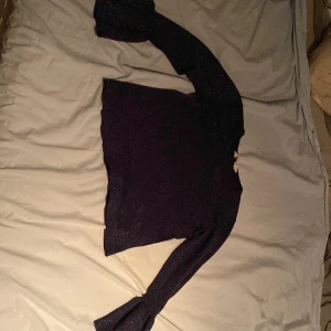 Tröja - En stickad tröja marinblå med glitter lite för kort för mig i armarna 