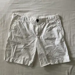 Lågmidjade vita shorts som är lite längre, men benen går att vika upp.  Begagnat fint skick, inga hål eller fläckar! Midjemått mätt rakt över: 39cm, längd: 38cm. Storlek 32 men passar även 34🫶💕