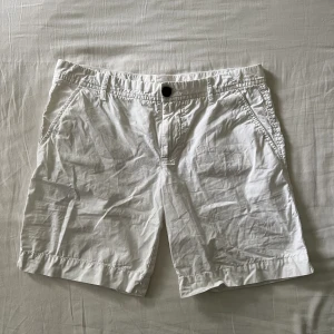 Low waist vita shorts - Lågmidjade vita shorts som är lite längre, men benen går att vika upp.  Begagnat fint skick, inga hål eller fläckar! Midjemått mätt rakt över: 39cm, längd: 38cm. Storlek 32 men passar även 34🫶💕