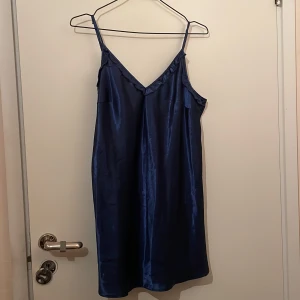 Blå klänning  - Marinblå satin klänning. Egentligen ett nattlinne men funkar lika bra att ha som klänning. Storlek 46 men passar många beroende på passform.
