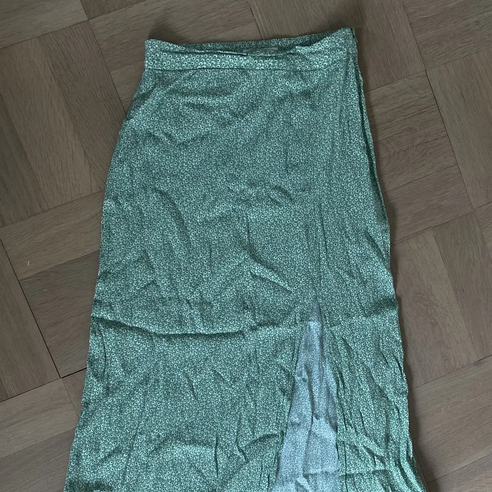Grön blommig kjol från H&M strl: 34.  Använd fåtal gånger, i fint skick.. Kjolar.