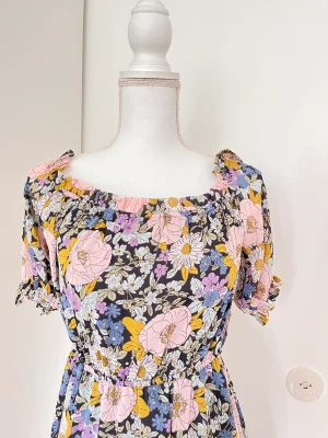 Blommig klänning  - En söt lång blommig klänning. Använd en gång. Har även en slits upp till knäet.