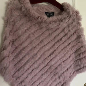 Rosa Poncho  - En jätte fin poncho med äkta päls från hollies som kostar 1000 kr men jag säljer den för 200 kr.