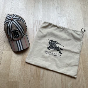 Burberry TB keps beige - Burberrys TB keps i beige färg. Storlek M. Perfekt skick, har aldrig använt. Säljer den för att jag själv inte använder den. Du får även med en burberry påse. Pris kan diskuteras