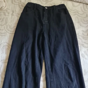 Ett par högmidjade svarta jeans. 40kr + frakt - Byxorna är nästan hely nya. Materialet är inte riktigt denim, skulle släga att det är tunnare. Byxorna är ifrån Shein och är i storleken 160 (64 i midjan, om det hjälper). Säljer dem för att de inte passar