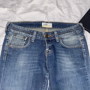 Lågmisjade lee jeans  - Jättesnygga detaljer,  nyskick! Står ingen storlek, men skulle uppskatta dom till 34.  Midjemått: 38cm Innerbensmått: 73cm 