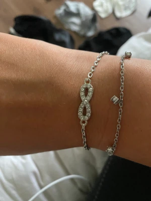 Armband med evighetstecken  - Armband med evighetstecken. Armbandet är upp till 20cm (justeringsbart). Ej använt, endast fotade på min arm. Inte äkta silver.         Frakt: 15kr eller 29kr spårbart (rekommenderat).  Paketpris på frakten. Du kan även bestämma storlek själv.