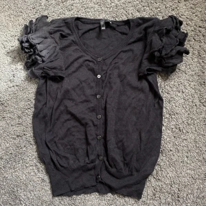 Kortärmad kofta  - Kortärmad kofta med volanger! Köpt på H&M för länge sedan men knappt använd. 