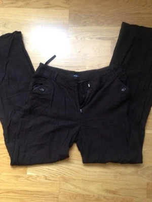 Bruna linnebyxor - Hål på rumpan och lite defekt gylf. Innerbenslängd 75 midjemått 42. jättefint att ha lågmidjat!