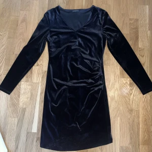 Svart klänning  - En svart långarmad klänning.  Klänningen är ganska varm samt använd fåtal gånger.  Säljer då den är förliten för mig. 