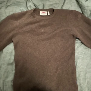 Fjälräven tjocktröja - Mysig brun tjocktröja från fjälräven.   Den är inte så oversized, sitter snyggt på kroppen. Cozy för sommarkvällar och bra för camping. Super bra skick.