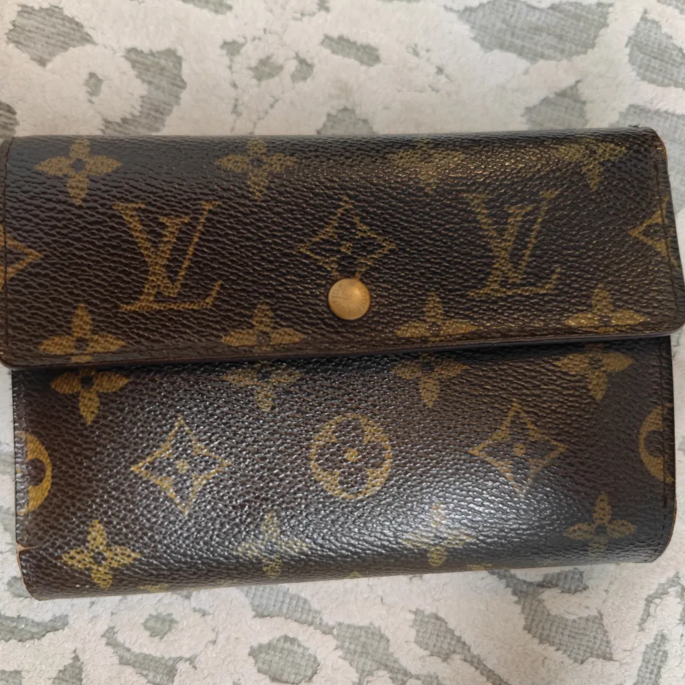 Unisex Louis Vuitton monogram Wallet och tillhörande original låda.   Fick den i present för en bra stund sen så finns inget kvitto dessvärre.  Knappen för att stänga är lite slö och den har signs of use (där av priset) men överlag fortfarande fin.   . Väskor.