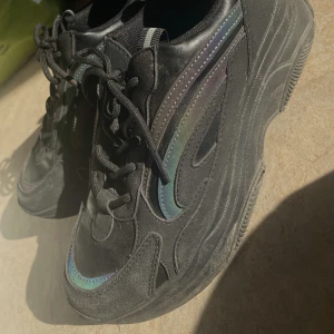 Sneakers strl. 39 - Storlek 39, svarta sneakers med dova färgdetaljer på sidorna. Använt fåtal gånger!