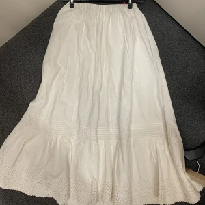 Vit långkjol  - Jättefint second hand fynd! Väldigt justerbar i midjan, passar alla!! Lite kort på mig som är 174, går inte hela vägen till marken. Men skulle gå ner till marken om man var lite kortare🥰