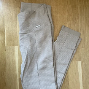 Träningstights - Amin tight i färgen beige från deras seamless lux kollektion. Endast använda enstaka gång då jag har lite för många par 😅 så de är i mycket fint skick!✨