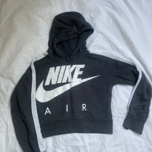 Nike hoodie - Mörkgrå Nike hoodie (magtröja? Vit text på framsidan o ingen text på baksidan. Vit sträck på ovansidan av armarna. Köpt för 400.