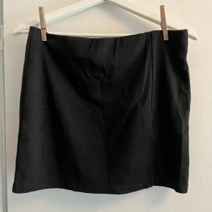 Svart kort kjol - Svart kort kjol med slit på sidan från Lager157.  Aldrig använd. Storlek M