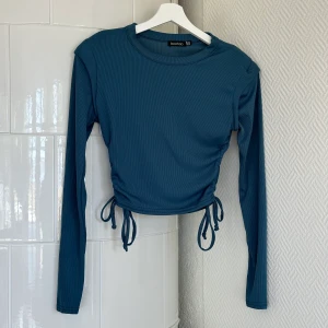 Topp - Långarmad topp från Boohoo med vadderade axlar och snörning vid sidorna. Aldrig använd! 🩵