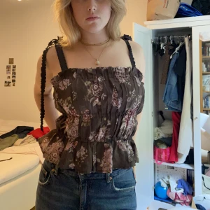 Topp - Blommig topp som är så himla fin, använd sparsamt så väldigt bra skick. Går att ha både med banden uppe och som bandau 