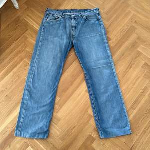Vintage Levis jeans med ett litet hål i ena byxöppningen, syns på bilden, annars bra skick