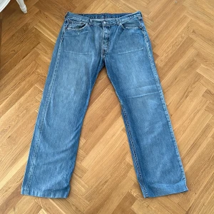 Vintage Levis Jeans 37W 32L - Vintage Levis jeans med ett litet hål i ena byxöppningen, syns på bilden, annars bra skick