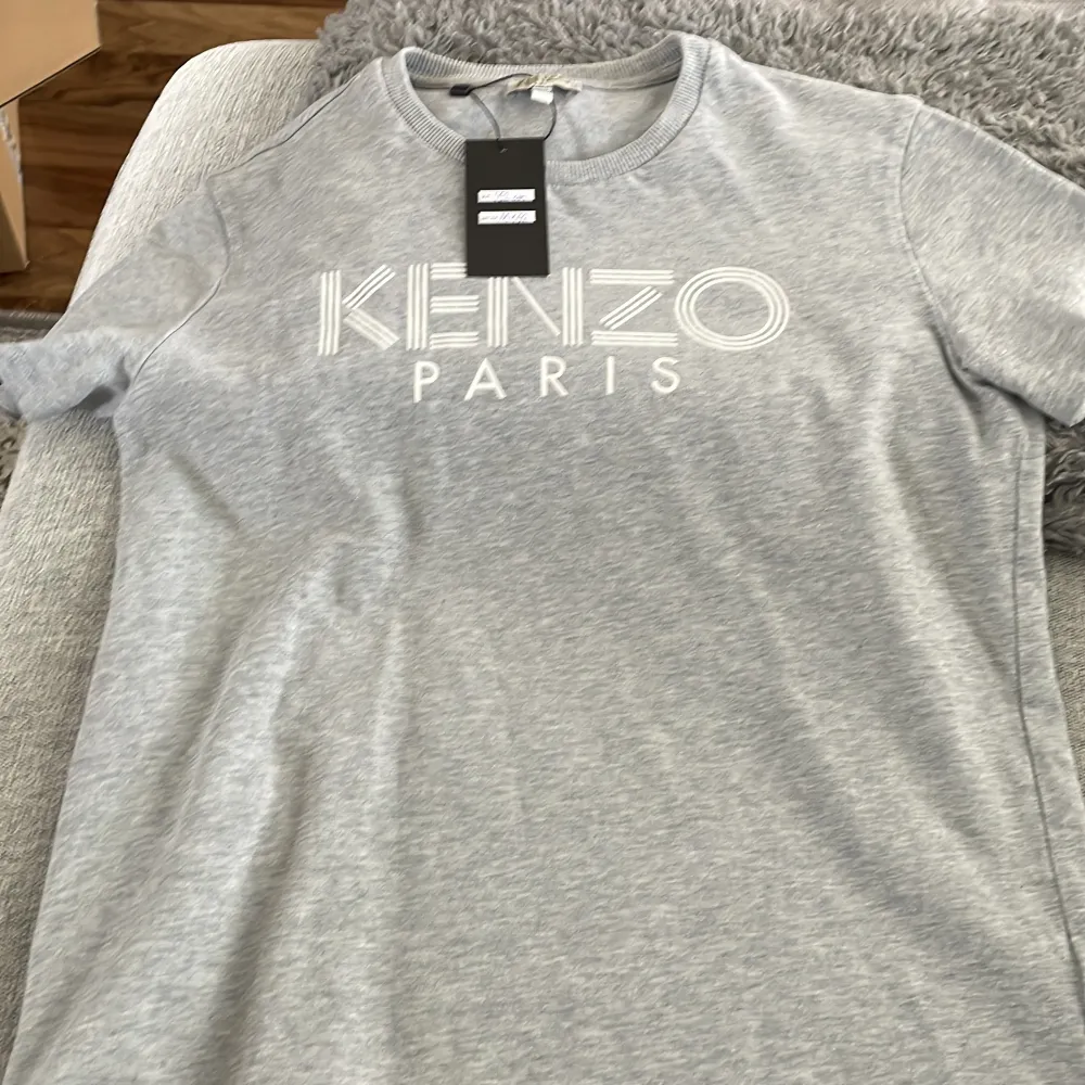 En helt ny Kenzo t shirt i grå.  Den är för kids Nypris: runt 650kr Pris 500kr Pris går att disskutera. T-shirts.