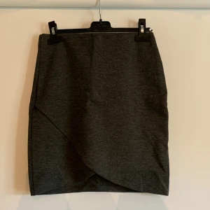 Grå minikjol - Grå minikjol från Gina Tricot, med overlappad tyg fram. Storlek XS, knappt använd. 