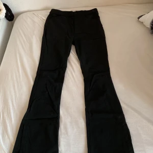 Svarta byxor. - Bra skick, går att spänna och lösa, ganska mjuka jeans, tillsydd detalj.