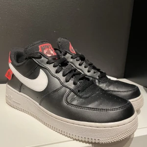 Nike Air Force 1 Worldwide - Nike Air Force 1 Worldwide, black/white/crimson, använda men i gott skick. Väldigt välskötta. Finns lite creasing