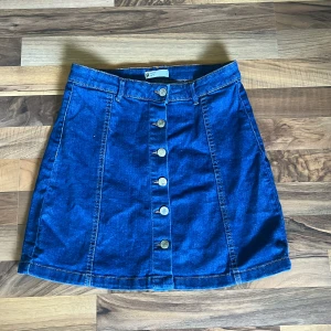 Jeanskjol - Kjol som kan användas till många olika tillfällen. Högmidjad och går till strax över knäna. Väldigt fint skick.