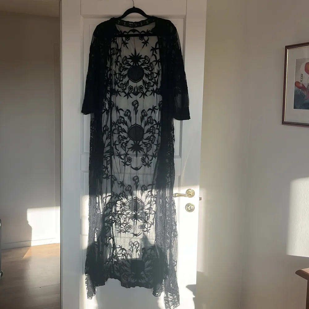 Lång svart mesh klänning/cardigan som användes en gång. Går ner till fotknölarna på mig (169 cm). Jättefin och inga skador/märken. Tröjor & Koftor.