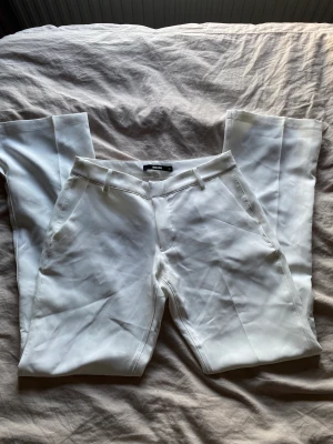 Lågmidjade kostymbyxor  - Lågmidjade kostymbyxor i vit💗 Säljer då dem aldrig kom till användning. Dem är bootcut med slits!