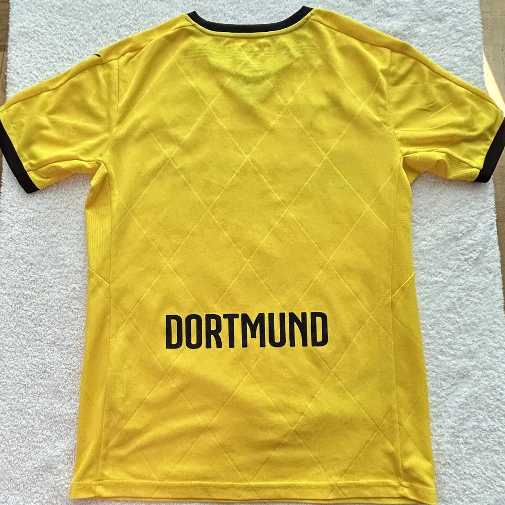 Dortmunds andra version av deras hemmatröja under 2015/2016 säsongen som de bara använda i europeiska tävlingar som Champions/Europa league.  Storlek: S Skick: 9/10. T-shirts.