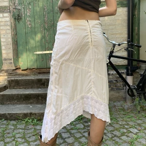 Vit kjol  - Asymmetrisk vit kjol. Tänk den, boots och en stickad tröja en sommarkväll! Köparen står för frakt. Köpt i Barcelona!