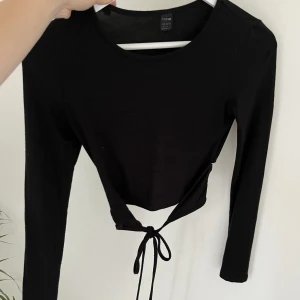 Tight långärmad  - Stretchigt material, knyte i ryggen, sitter tight 