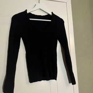 Svart långärmad tröja  - Säljer min svarta långärmade tröja med volanger upptill som jag använt några gånger. Fin till vardags och hemma, skola osv. Fint skick. 