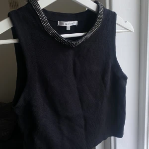 Svart topp - Oxygene, spikstickad ärmlös tröja för kvinnor i svart.