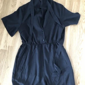Jumpsuit  - Jumpsuit me korta ben å knäppning. Endast testad       Mått: Axel: 39cm, Längd: 81.5 cm,    Ärmlängd: 24cm, Byst: 94cm, Höft storlek: 114cm, Manc hett: 44.2cm     