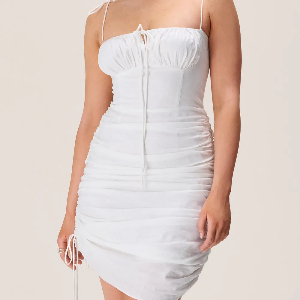 Säljer nu min vita fina adooreklänning i storlek XS/34 då den ej kommer till användning. Använd 2ggr och är som ny!. Klänningar.