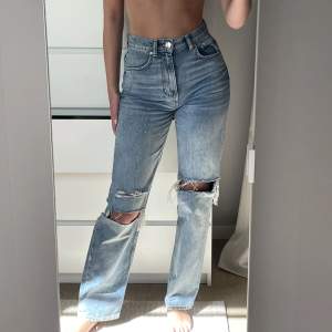 Mellanblå jeans med slitningar från Gina. Storlek 34.