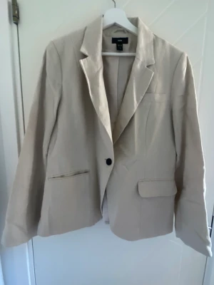 Beige kavaj  - Beige oanvänd kavaj från H&M.