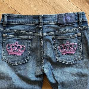 Säljer mina Victoria Beckham bootcut jeans med rosa kronor! Väldigt sällsynta och går ej att få tag på längre! Midjemått: 40 cm rakt över. Innerbenslängd: 81 cm