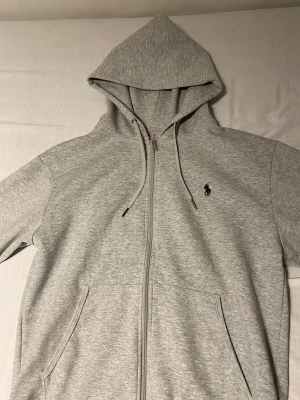 Ralph lauren zip hoodie - Hej! Jag säljer min grå ralph lauren hoodie i storlek M som jag använt en gång. Jag säljer den för att jag hade beställt fel storlek och insåg det efter jag ryckt lappen. Nypris 1799kr men jag säljer den för 700kr. Priset kan diskuteras vid snabb affär!